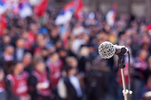 mic on a stand with a large crowd blurred out in the background