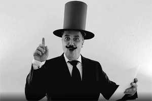 B&W photo of Steve Smith in top hat & fake mustache holding paper and pointing