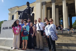 Group of students with their chaperone at an unknown monument. 