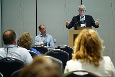 Male presenting from behind a podium.