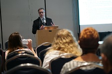 Male presenting from behind a podium.