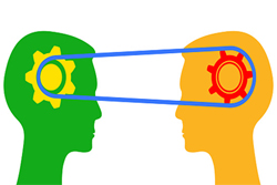 On the left is a green silhouette of a head across from a yellow silhouette of a head on the right with a pulley and gears connecting the minds of the two heads.