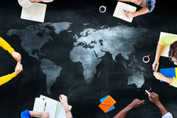 World map with people drawing on the map or in notebooks around the outer edge of the image.