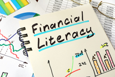 Photo of a book titled "Financial Literacy" whose cover is handwritten and decorated using colored marker.