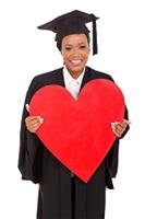 student graduating holding cut out red heart