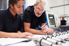 Two professionals working together on what appears to be an engineering task.