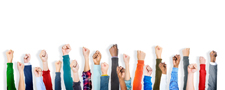 Dozens of fists raised in the air against a white background.