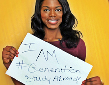 Female of color holding a sign that says "I am #Generation Study Abroad".