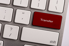 Photo of a keyboard with the enter key replaced by a red key that says "transfer."