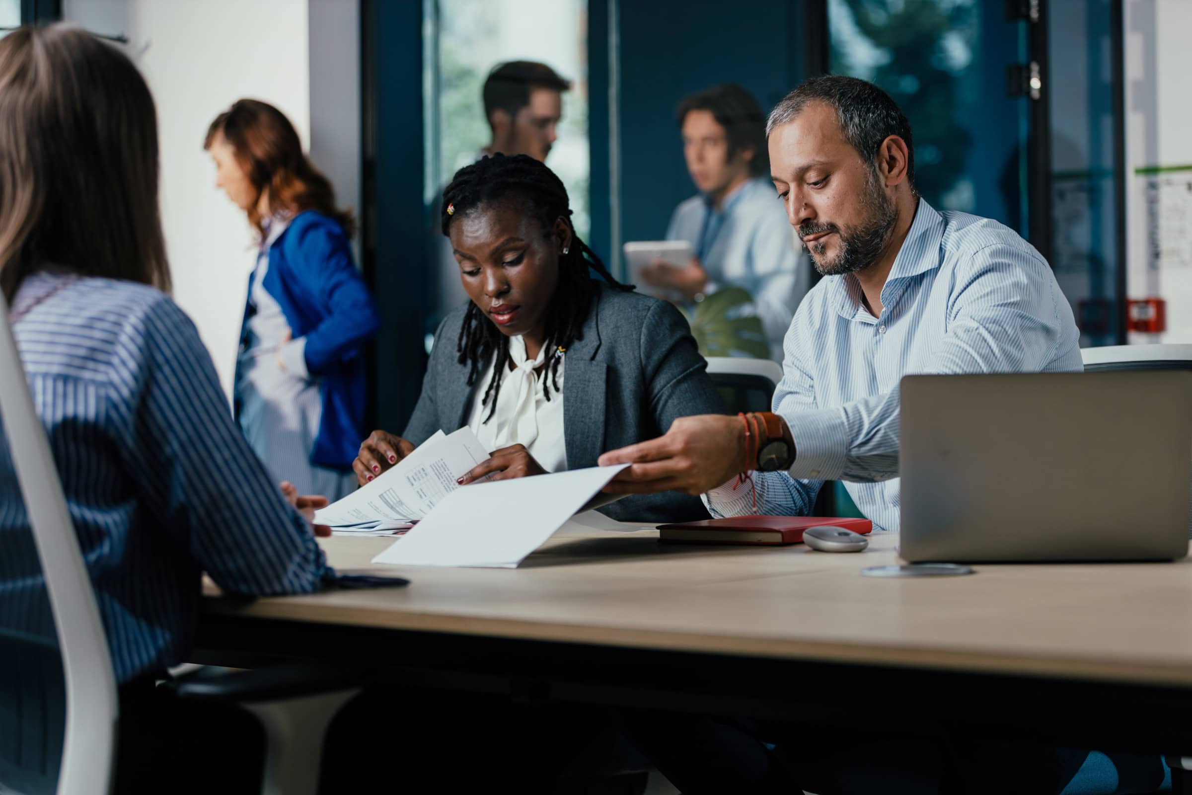 Office meeting with colleagues reviewing documents at a conference table