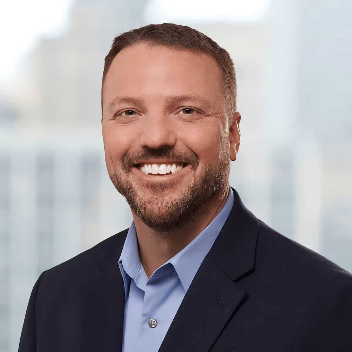 Portrait of a smiling man in a suit and blue shirt