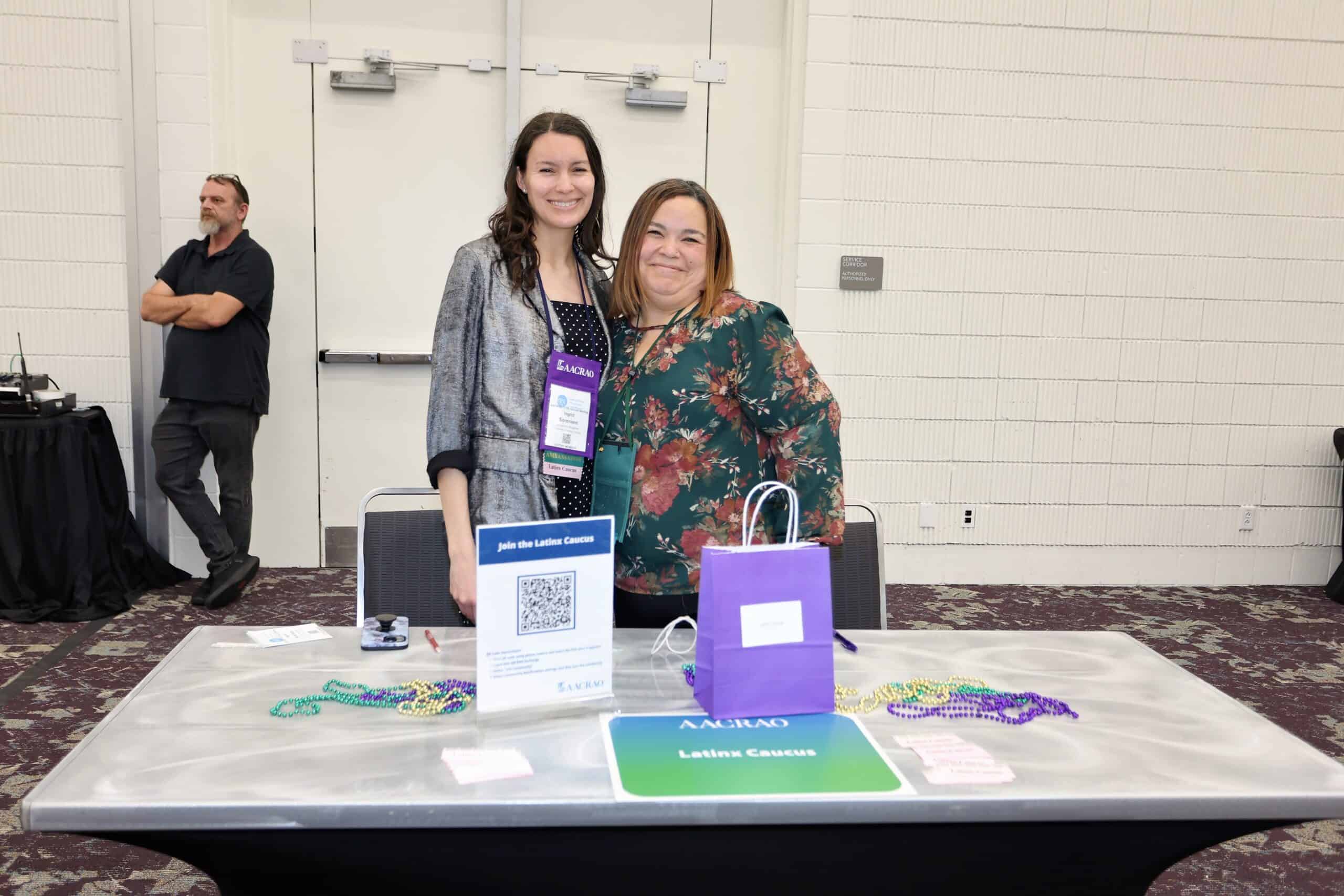 Two members at the AACRAO Raíces Caucus table