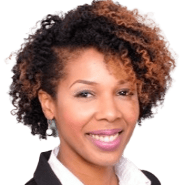 Portrait of a smiling woman with curly hair wearing a black blazer and white shirt