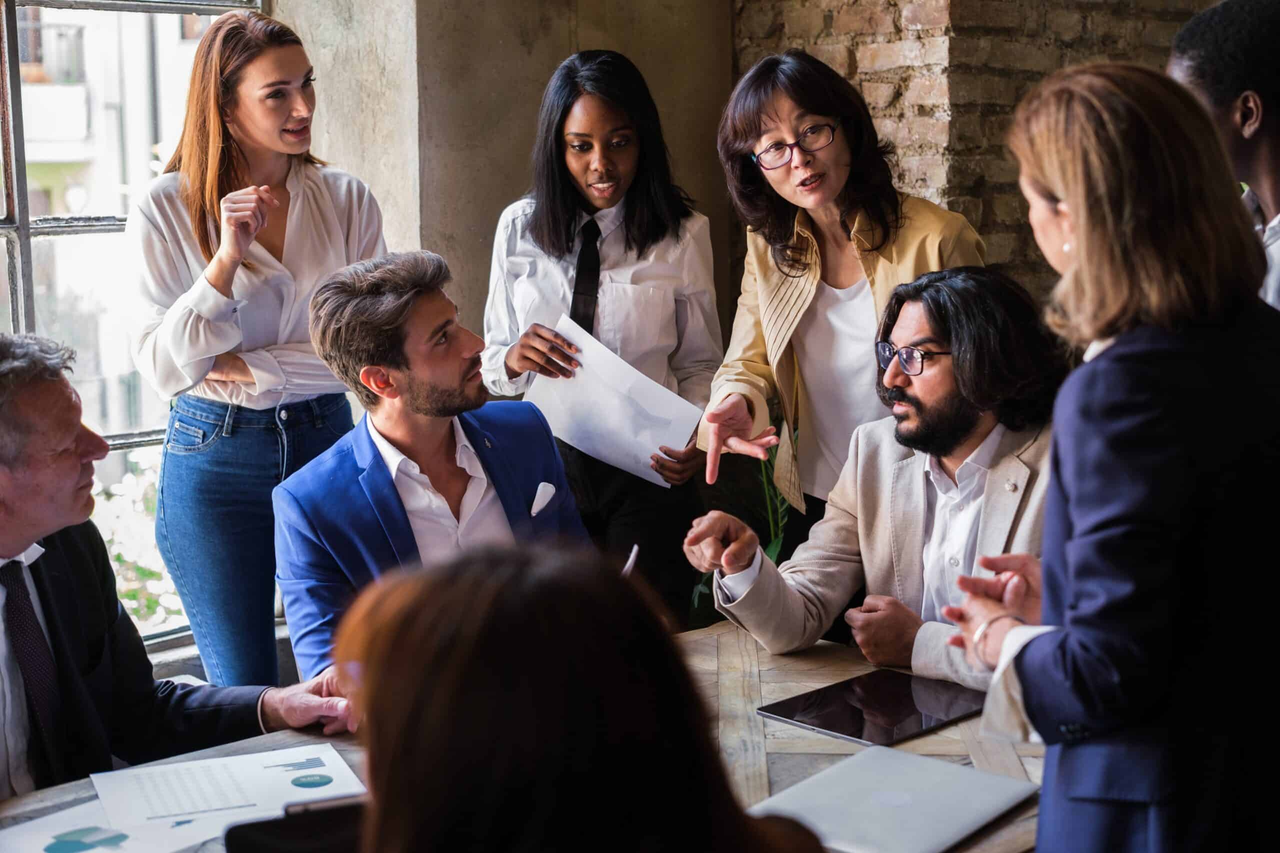 Colleagues discussing a project around a table in a meeting room