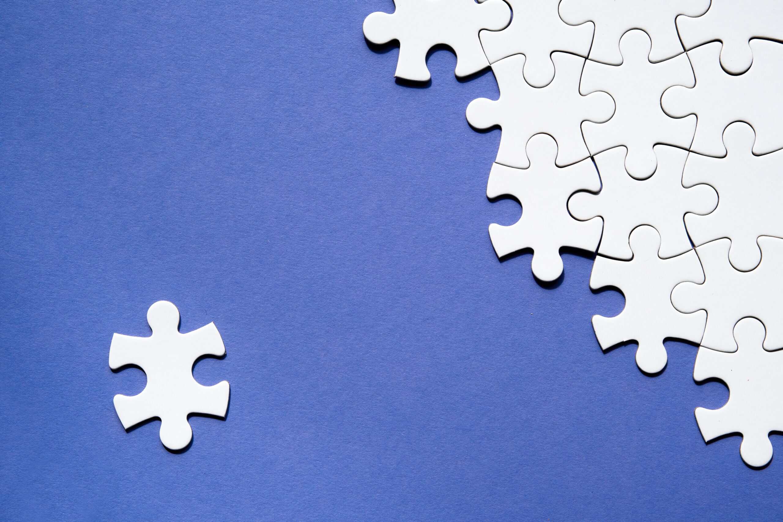 white puzzle pieces in a blue background