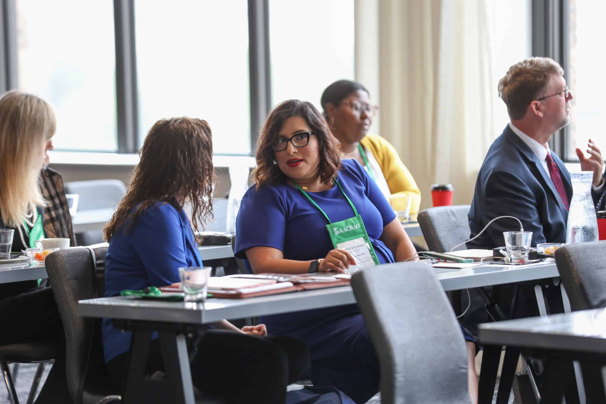 Attendees networking at an AACRAO conference session.