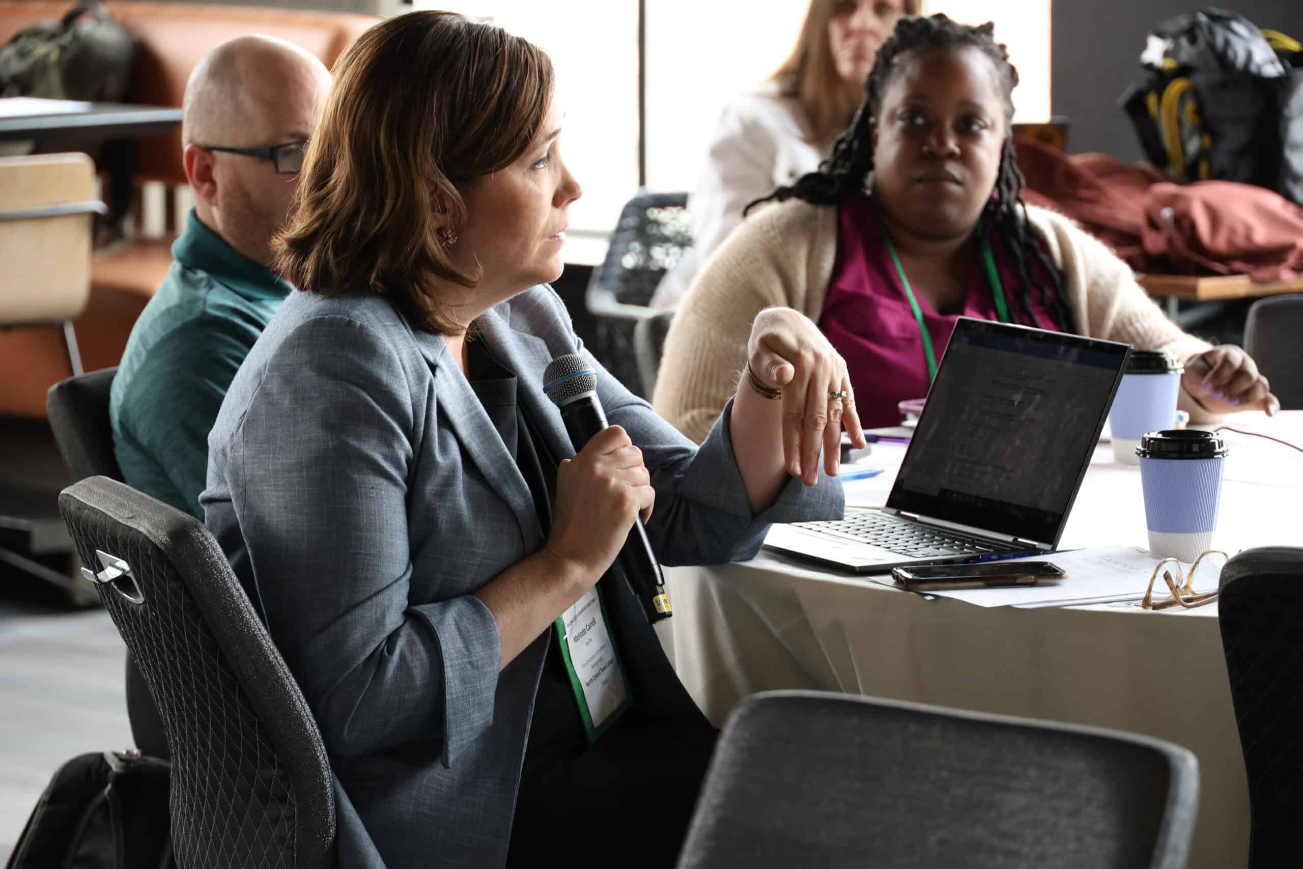 Conference attendee speaking into a microphone at an AACRAO session.