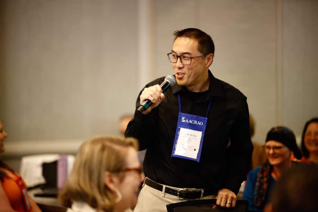 Man speaking into a microphone at a conference