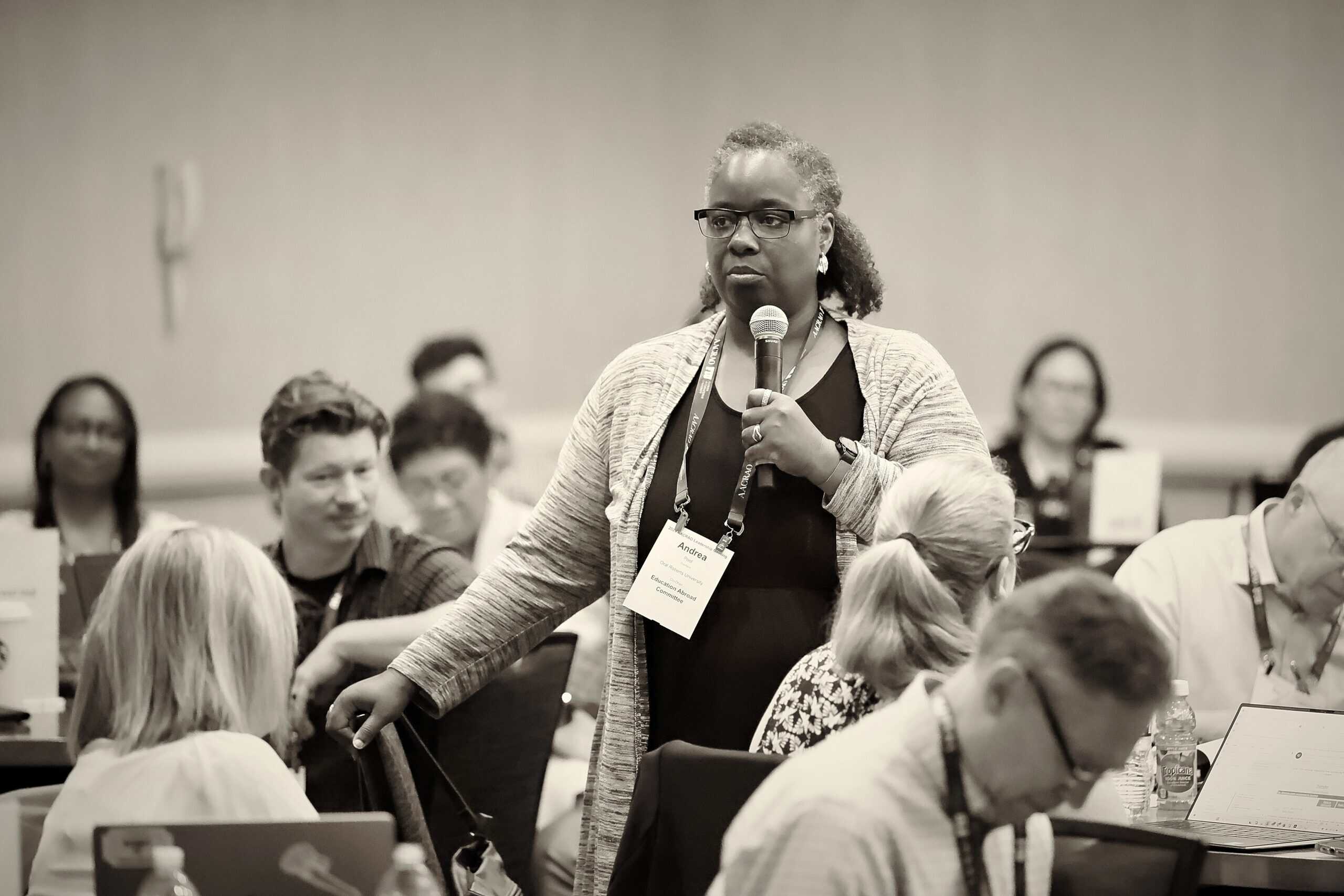 Woman speaking into a microphone at a conference session