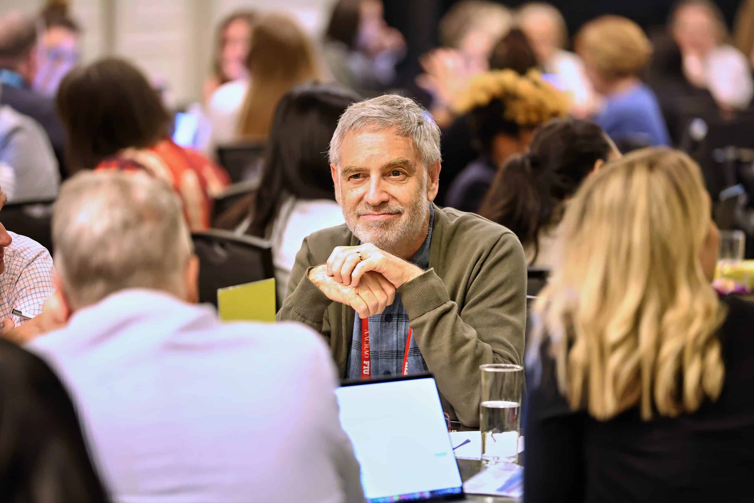 Man smiling at a busy conference event