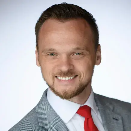 Nick Jobe in a grey suit and red tie