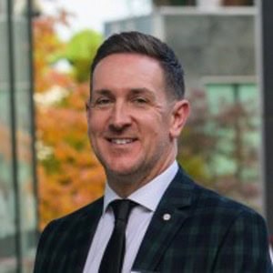 Portrait of a smiling man in a suit and tie outdoors