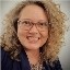 Portrait of a smiling woman with curly hair and glasses