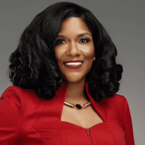 Portrait of a smiling woman in a red jacket against a gray background