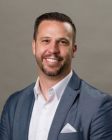 Portrait of a smiling man in a blue blazer and white shirt