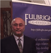 Fulbright banner behind a man in a suit and tie