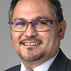 Portrait of a smiling man wearing glasses and a suit jacket