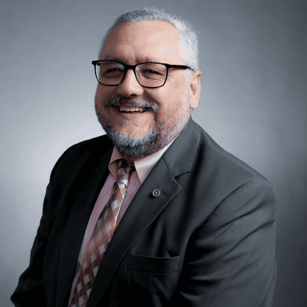 Portrait of a smiling man in a suit and tie wearing glasses