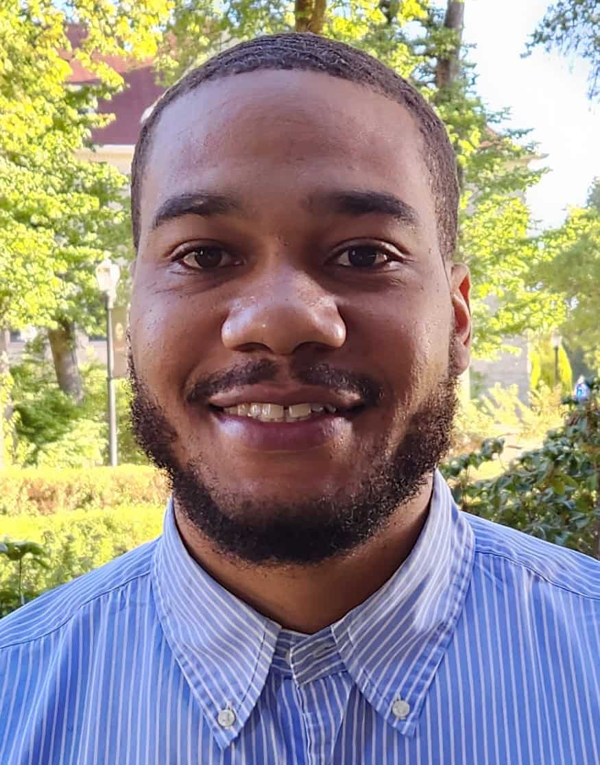 Smiling man with a blue and white collared shirt