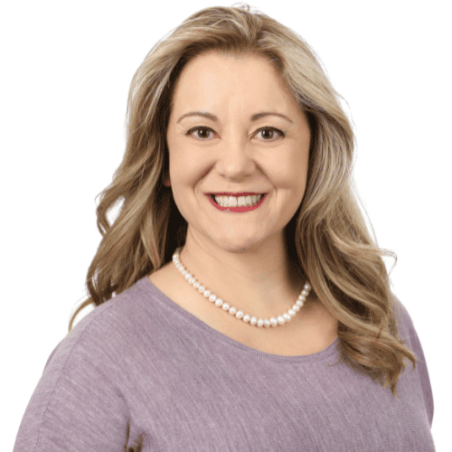 Portrait of a smiling woman wearing a pearl necklace and purple top