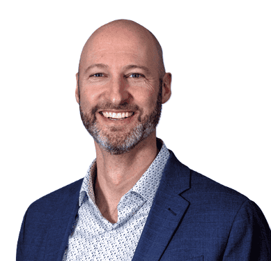 Portrait of a smiling bald man with a beard wearing a blue blazer and patterned shirt