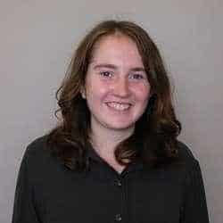 Portrait of a smiling woman with shoulder-length brown hair wearing a black shirt