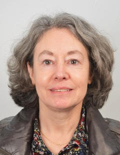 Portrait of a middle-aged woman with gray hair, facing forward against a plain background