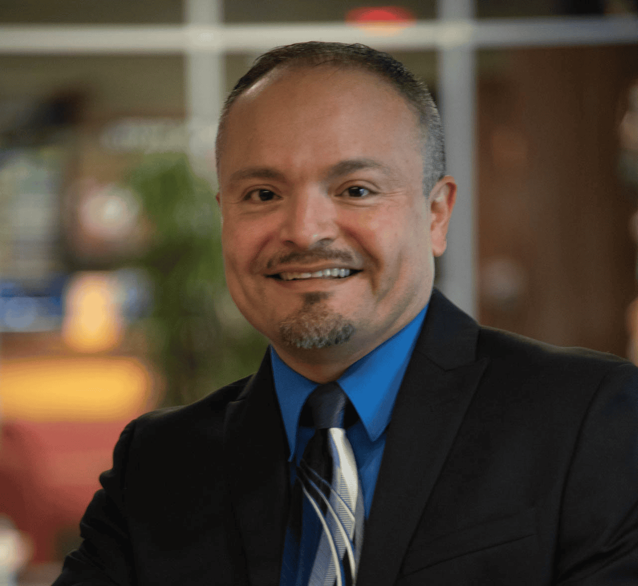 Portrait of a smiling man in a suit and blue shirt