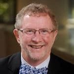 Portrait of a smiling man wearing glasses and a bow tie