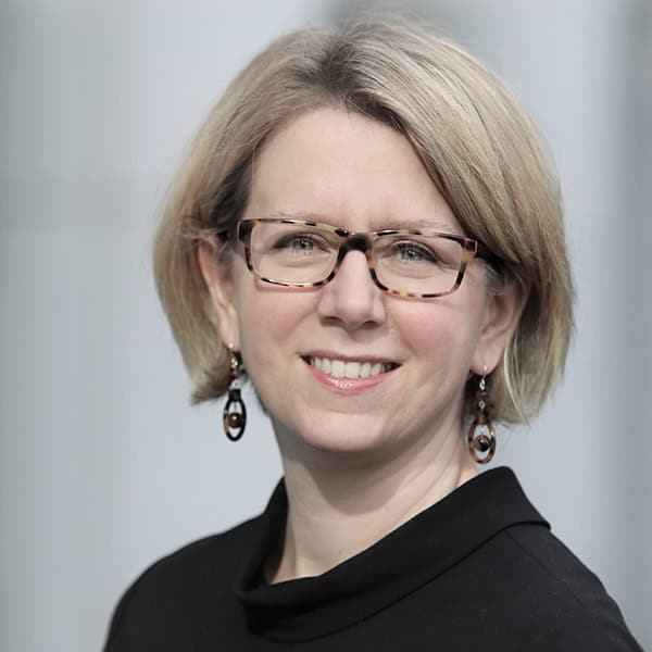 Portrait of a smiling woman wearing glasses and earrings