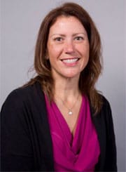 Portrait of a smiling woman in a magenta blouse and dark cardigan