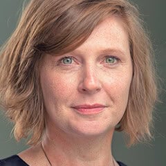 Portrait of a woman with short light brown hair and a neutral expression