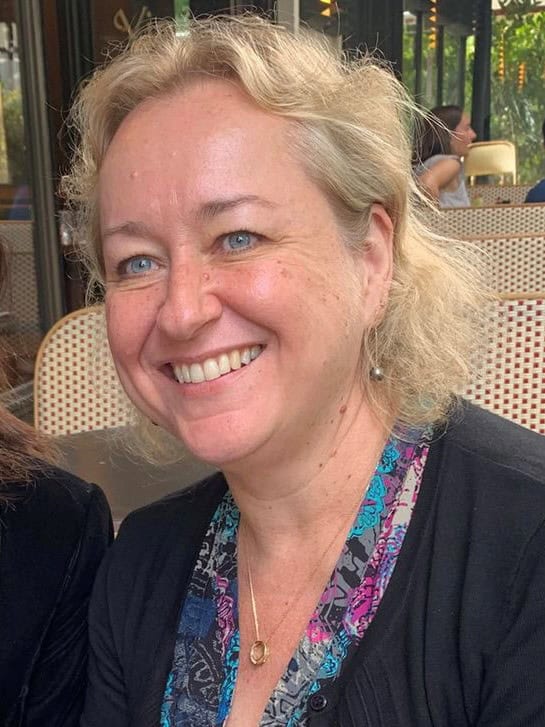 Smiling blonde woman sitting at an outdoor café