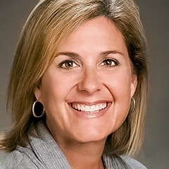 Portrait of a smiling woman with blonde hair and hoop earrings
