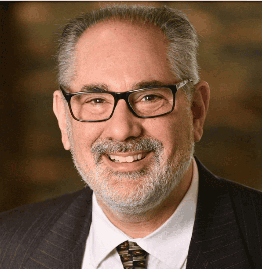 Portrait of a smiling man in glasses and a suit