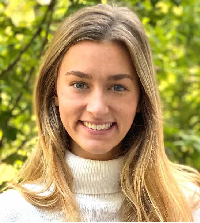 Portrait of a smiling woman with long blonde hair in a white turtleneck sweater
