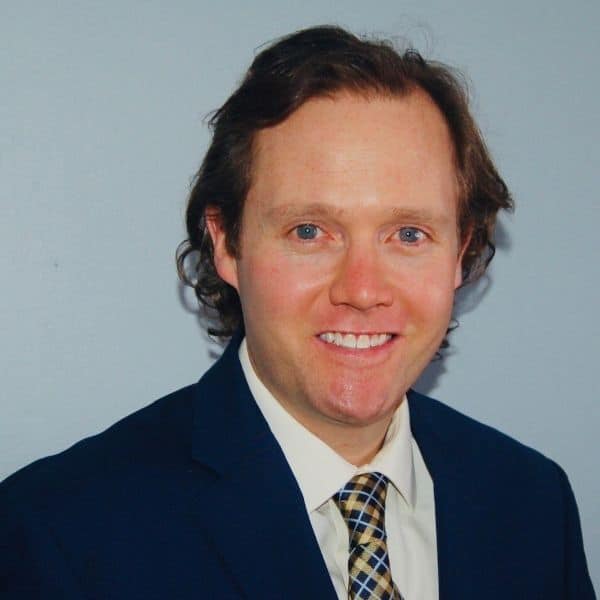 Portrait of a man in a suit and tie smiling at the camera