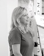 Woman standing in profile, looking at a wall display or poster