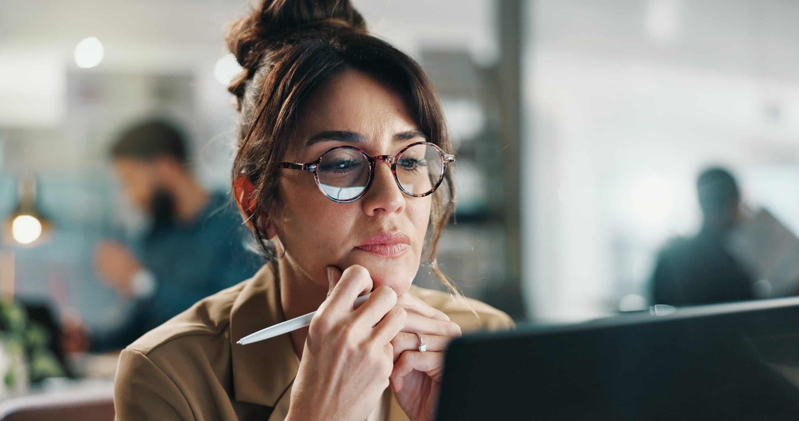 woman wearing glasses looking at her notebook.