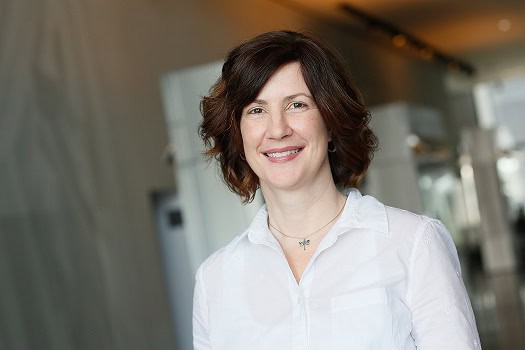 Portrait of a smiling woman in a white shirt indoors